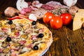 Close up of tasty pizza, tomatoes, mushrooms and cutting board w Royalty Free Stock Photo