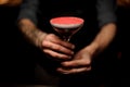 Close-up of tattooed bartender holding an alcohol cocktail