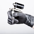 Close-up of Tattooist hands in black gloves with tattoo machine