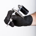 Close-up of Tattooist hands in black gloves with tattoo machine Royalty Free Stock Photo