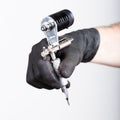 Close-up of Tattooist hands in black gloves with tattoo machine