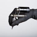 Close-up of Tattooist hands in black gloves with tattoo machine