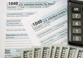 Close up of 1040 tax forms with dollars and calculator. Tax time concept. Financial document. Royalty Free Stock Photo