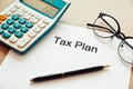 Close up tax planning word on paper with calculator, pen and eye glasses place on the wooden table Royalty Free Stock Photo