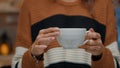 Close up of tea cup held by young woman at home Royalty Free Stock Photo