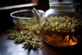 close-up of tea leaves steeping in a glass teapot