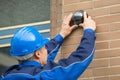 Close-up Of Technician Installing Camera In Building