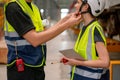 Close up technician man help to set or fix problem of strap of hardhat of engineer or factory worker woman and they stay in