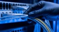 Gloved IT Professional Securing Data Cable Connections in a Server Room for Optimal Network Performance. Royalty Free Stock Photo