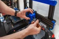 Close-up of technician's hands doing maintenance on 3D printer