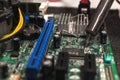 close up of a IT technician soldering a part of a computer motherboard in an office Royalty Free Stock Photo