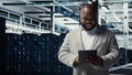 Close up of technician walking in data center, using tablet to check equipment Royalty Free Stock Photo