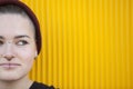 Close up of a teen lesbian woman on a yellow wall