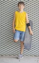 A teenage boy carrying skateboard and smiling Royalty Free Stock Photo