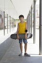 A teenage boy carrying skateboard and smiling Royalty Free Stock Photo