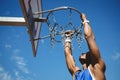 Close up of teenage boy hanging on basketball hoop Royalty Free Stock Photo