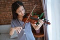 Close up of teenage girl learn to play a violin instrument in a room