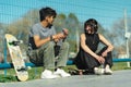 Close up of teenage skaters talking and resting in the park. Selective focus Royalty Free Stock Photo