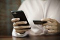 Close up of a teenage woman holding credit card and smart phone make online payment Royalty Free Stock Photo