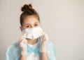 Close-up teenager girl in surgical protective mask and rubber gloves on a neutral gray background. virus protection concept