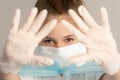 Close-up teenager girl in surgical protective mask and rubber gloves on a neutral gray background. virus protection concept