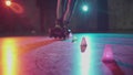 Close-up of teenager legs roller skating around obstacles in slow motion. Millennial showing trick freeskating in dark