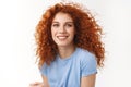 Close-up tender alluring redhead woman with curly hair that floats in air, smiling joyfully and coquettish gaze camera