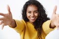 Close-up tender and cute pretty african american curly-haired woman in yellow sweater stretchin hands forward, smiling