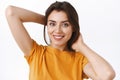 Close-up tender, feminine alluring young stylish caucasian woman in yellow t-shirt, holding hands behind as mend her Royalty Free Stock Photo