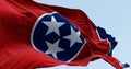 Close-up of the Tennessee state flag waving. Red field with a blue circle in the center containing three white stars. US state