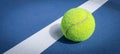 A close-up of the tennis ball on the court. The blue background is a beautiful illustration and background. Close-up shots of tenn