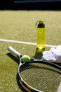 Close up of tennis ball, racket, towel and water bottle at tennis court Royalty Free Stock Photo