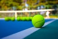 Tennis ball on white Court line on hard modern blue court with Net balls player trees in the background Royalty Free Stock Photo