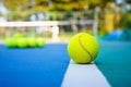 Tennis ball on white Court line on hard modern blue court with Net balls player trees in the background Royalty Free Stock Photo