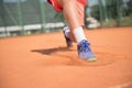 Close up of tennis player glide on the court. Sunny day. Royalty Free Stock Photo