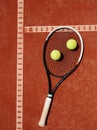 Close up of tennis racket and yellow balls at red clay Royalty Free Stock Photo