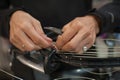 Close up of tennis stringer hands doing racket stringing