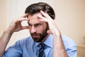 Close up of tensed man with hands on forehead