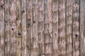 Close up texture background shot of an old grayed out weathered vertical wood fence made with rough sawn scraped planks with knots