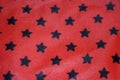 Close-up texture of a red fabric with black stars Royalty Free Stock Photo