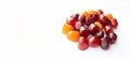 Close-up texture of red, orange and purple multivitamin gummies on white background. Healthy lifestyle concept