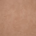 A close-up texture of a reddish-orange or terracotta surface with a rough, uneven texture, resembling a wall Royalty Free Stock Photo