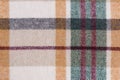 close-up texture of warm checkered tartan fabric in beige, green and red colors. Image for your design. material for making warm