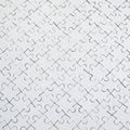 Close up texture of a white jigsaw puzzle in assembled condition. Top view. Many components of a large whole mosaic are united Royalty Free Stock Photo