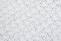 Close up texture of a white jigsaw puzzle in assembled condition. Top view. Many components of a large whole mosaic are united Royalty Free Stock Photo