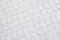 Close up texture of a white jigsaw puzzle in assembled condition. Top view. Many components of a large whole mosaic are united Royalty Free Stock Photo