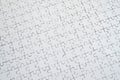 Close up texture of a white jigsaw puzzle in assembled condition. Top view. Many components of a large whole mosaic are united Royalty Free Stock Photo