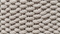 Close-up of textured, beige knitted fabric, showing a repeating pattern. Royalty Free Stock Photo