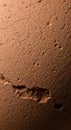 Close-up of a textured brown surface with small craters and cracks, resembling the Royalty Free Stock Photo