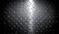 close-up of a textured, dark metallic diamond plate surface with highlights and shadows Royalty Free Stock Photo